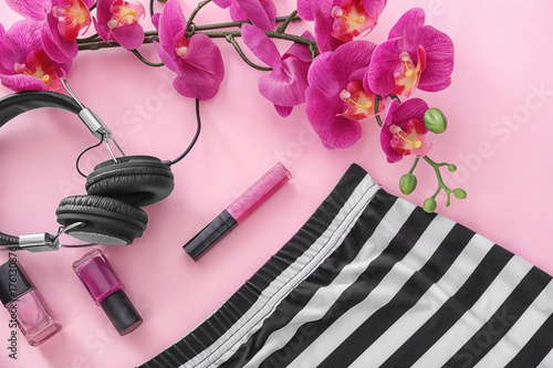 Composition with headphones, cosmetics and flowers on color background. Beauty blogger concept