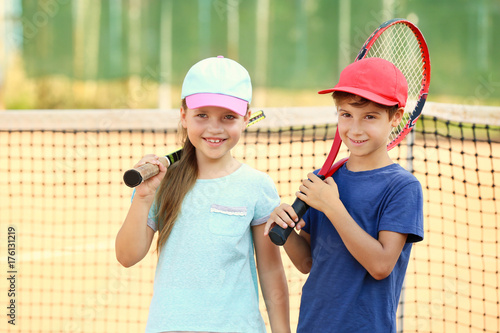 Cute little children on tennis court