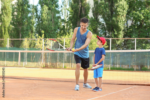 Young trainer with little boy on tennis court © Africa Studio