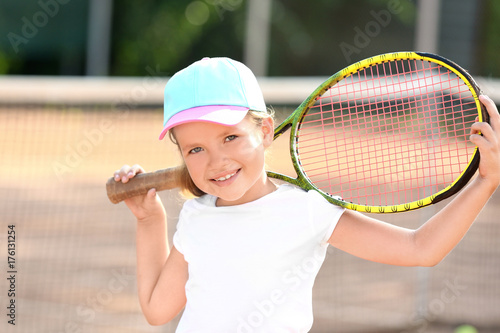 Cute little girl with tennis racket on court © Africa Studio