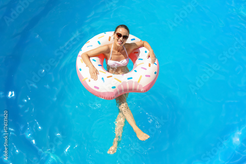Young woman with inflatable donut in swimming pool