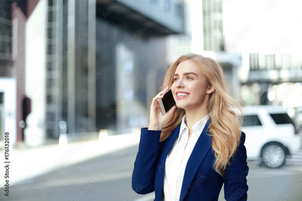 Young businesswoman talking on mobile phone outdoors Young businesswoman talking on mobile phone outdoors