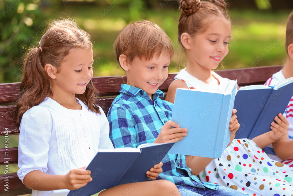Cute little children reading books in park Cute little children reading books in park