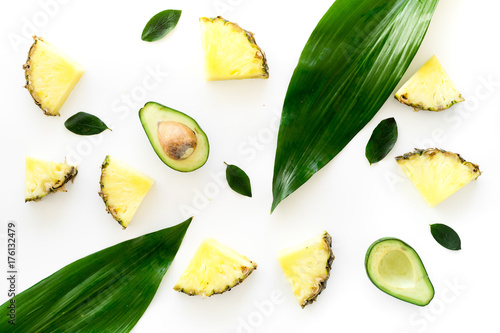 Pinneapple slices and leaves pattern on white background top view photo