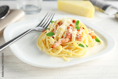 Plate of pasta carbonara with bacon on table