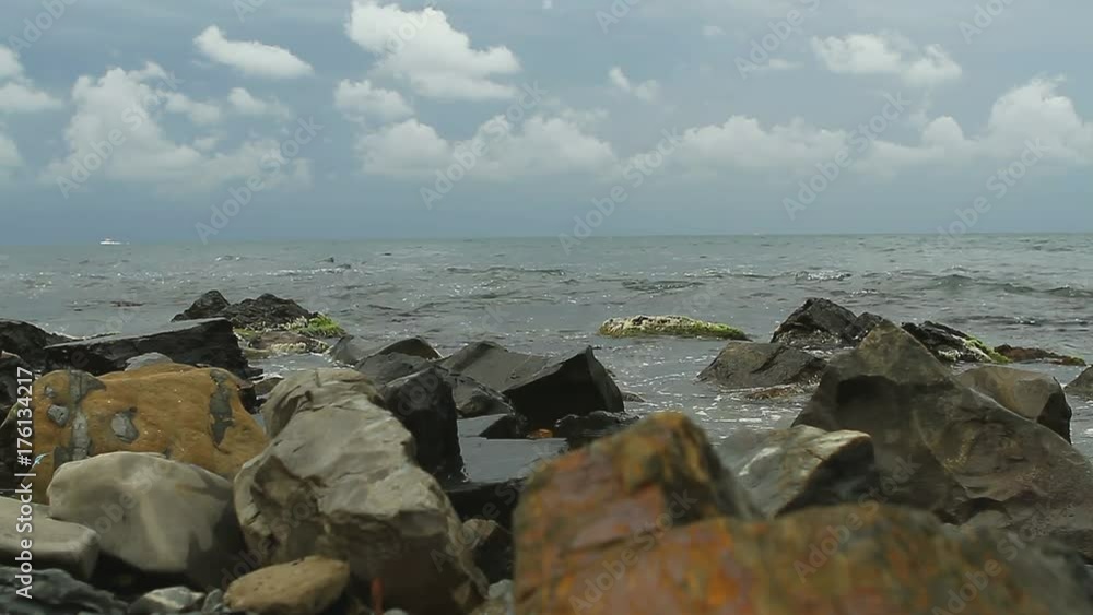 Storm surges of the sea washed the rocky beach with views of the mountains. Black Sea coast of Russia. Sea foam scatters to the winds. surf on the rocky coast. Storm surges of the sea washed the rocky beach with views of the mountains. Black Sea coast of Russia. Sea foam scatters to the winds. surf on the rocky coast.