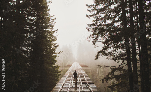 man standing on that PNW bridge on a foggy day