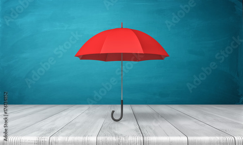 3d rendering of a single red classic umbrella with an open canopy standing above a wooden desk on blue background.