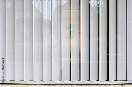 White modern structure of metal perforated vertical panels.