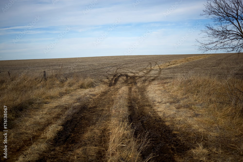 Dirt track leading through dry grassy farmland Dirt track leading through dry grassy farmland