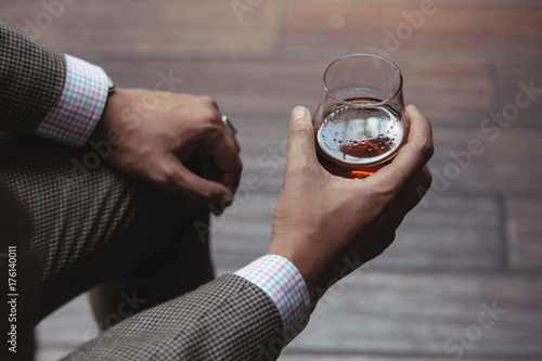 Dapper gentleman holding a glass of rum