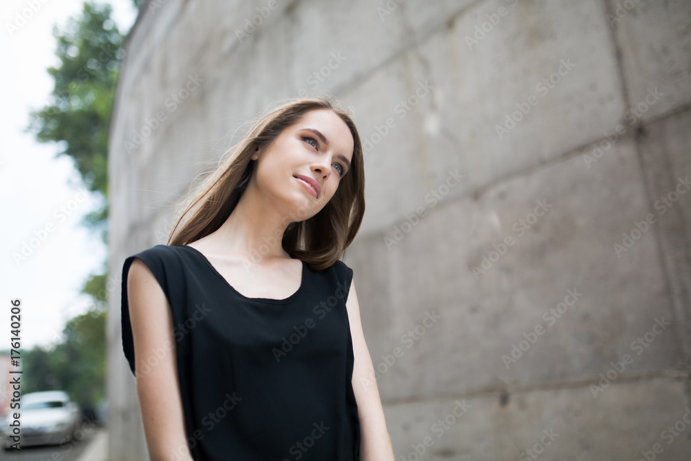 Portrait of young beatiful girl dreaming outdoors. Sensual woman outdoors againsr grey wall. Portrait of young beatiful girl dreaming outdoors. Sensual woman outdoors againsr grey wall.