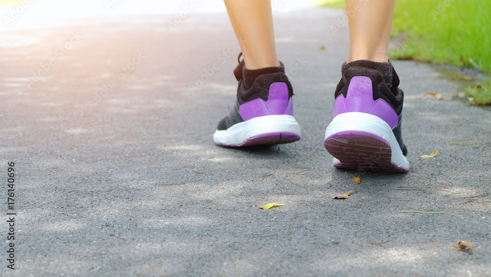 Women wearing fitness shoes are running on park roads.