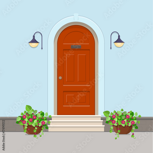  Orange front door with electric lanterns on the wall and flowers in the pots
