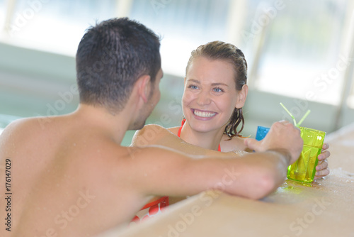 couple enojying drinks in swimming pool