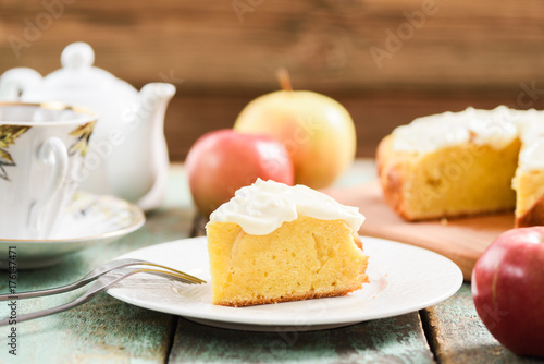 Homemade delicious cake with whipped cream served with tea and raw apples