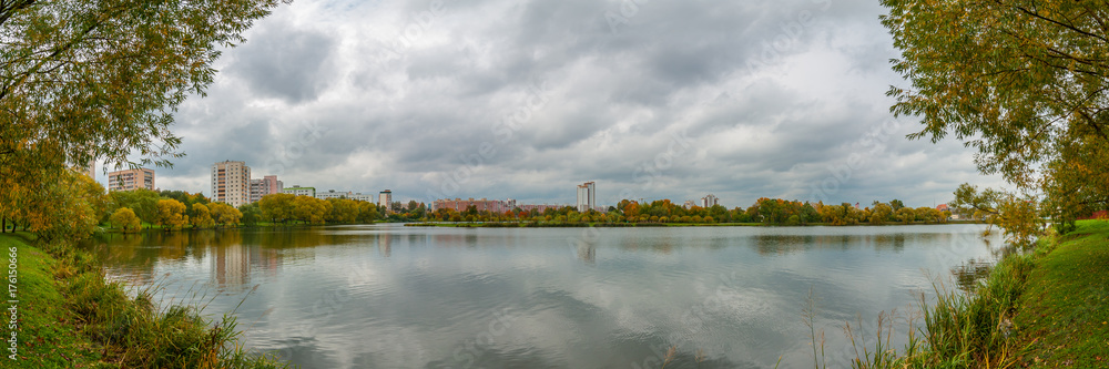 autumn panoramic view of the city quarter on the shore of the lake in cloudy weather
