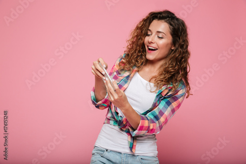 Young concentrated lady playing games on smartphone isolated