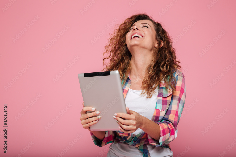 Young caucasian brunette lady using tablet computer isolated over pink Young caucasian brunette lady using tablet computer isolated over pink