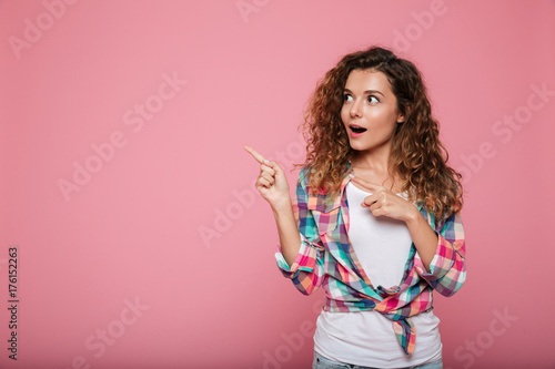 Surprised lady pointing at copy space isolated