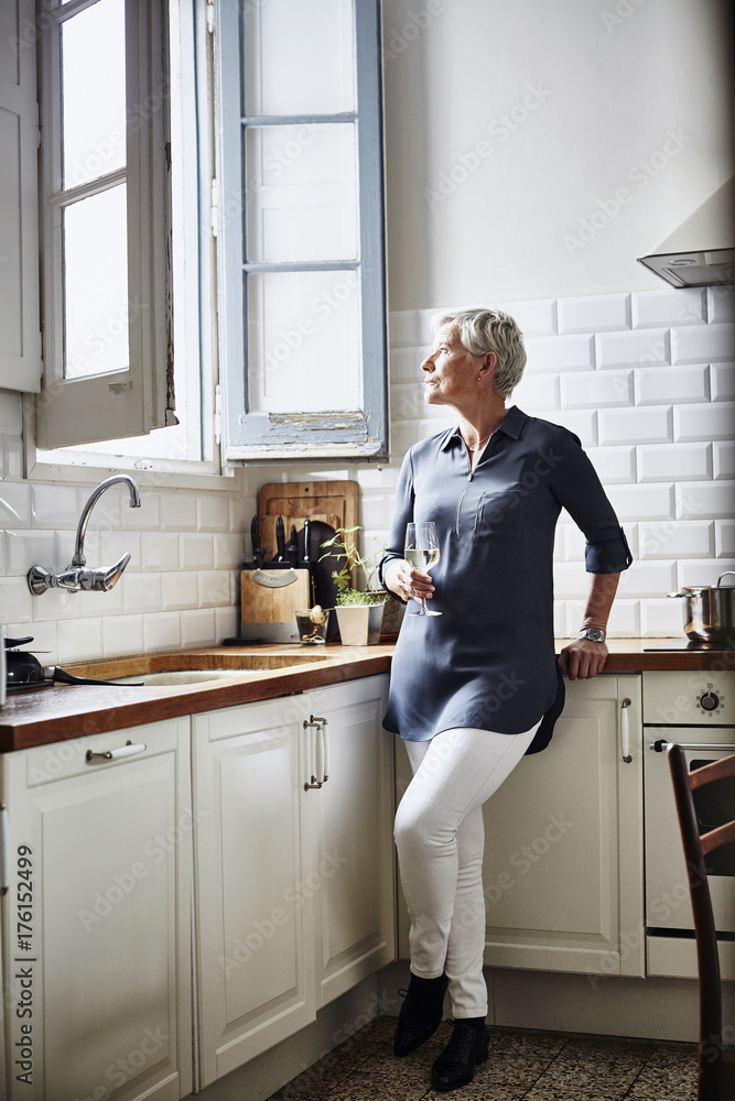 Senior Woman Holding Glass Of Wine In Kitchen Senior Woman Holding Glass Of Wine In Kitchen