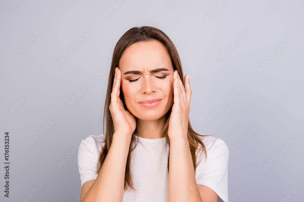 Strong migraine. Struggling beautiful young lady with strong pain grimace. She is wearing the casual white outfit, standing on pure background Strong migraine. Struggling beautiful young lady with strong pain grimace. She is wearing the casual white outfit, standing on pure background