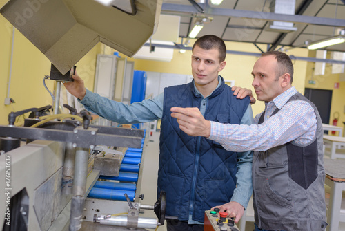 factory manager and engineering apprentice discussing component