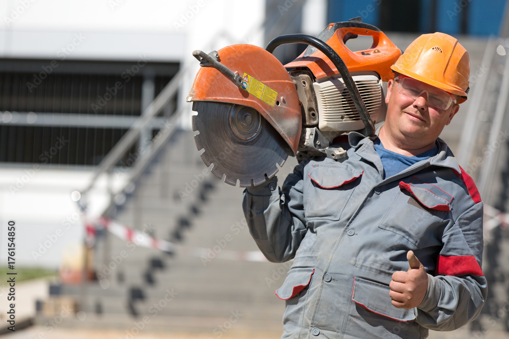 Construction man worker with petrol disc cutter gesturing ok sign outdoors Construction man worker with petrol disc cutter gesturing ok sign outdoors