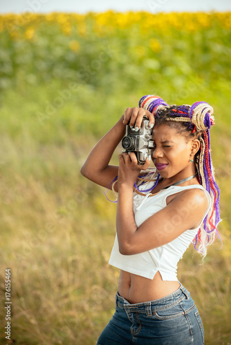 people, photography, technology, leisure and lifestyle - happy young african american female photographer looking to vintage camera