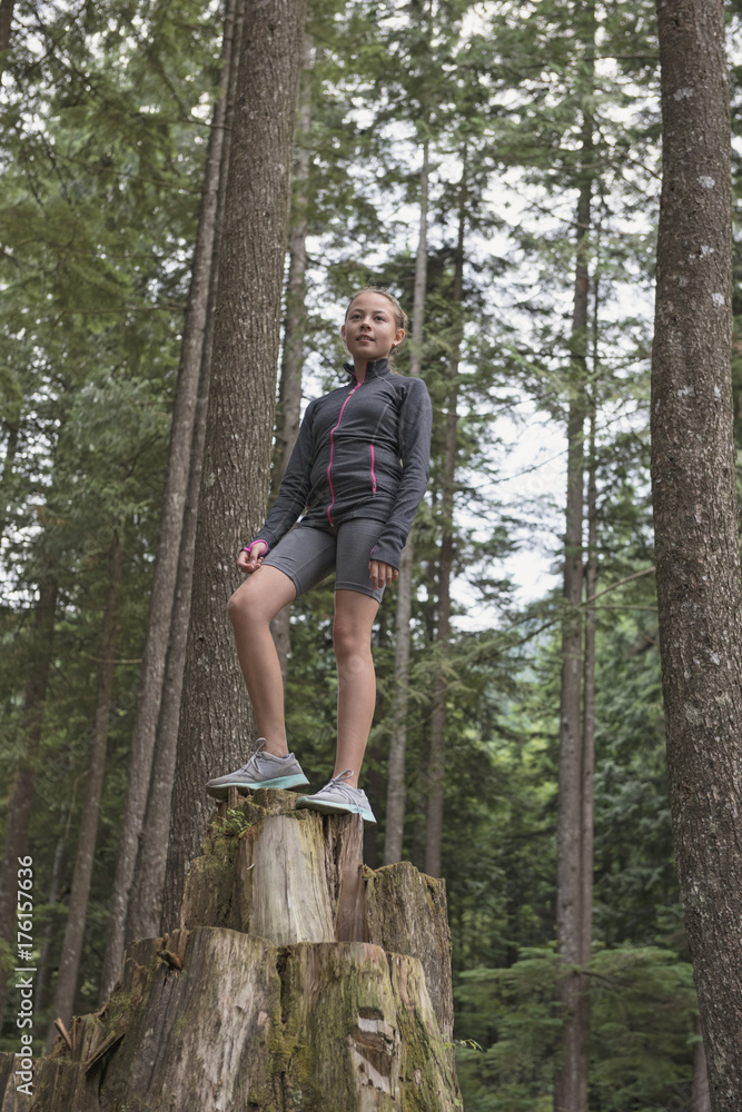 Preteen Girl Standing On Stump In Forest Preteen Girl Standing On Stump In Forest