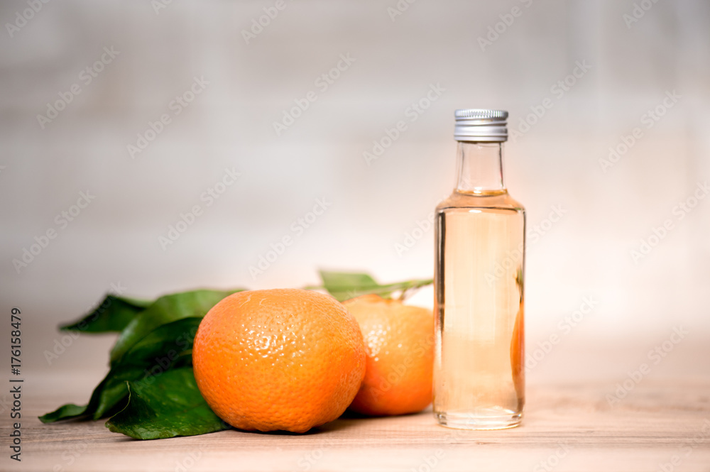 Bottle of orange oil on a wooden table Bottle of orange oil on a wooden table