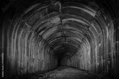Fototapeta Głęboki i tajemniczy ciemny tunel zaprasza zwiedzającego do odkrycia