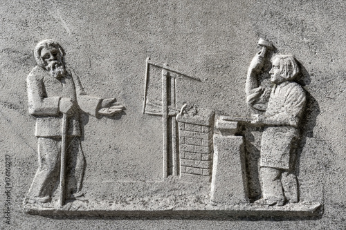 Photos Beggar with outstretched arm and blacksmith with hammer and anvil, detail of an