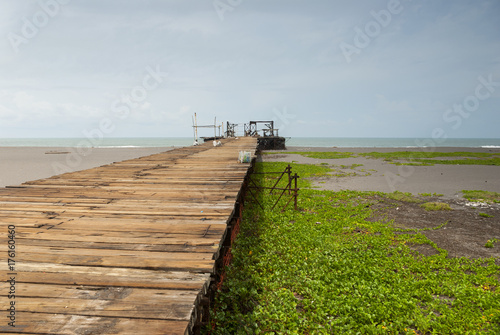 Old rusty pier in Guatemala shot in a cloudy morning. Champerico