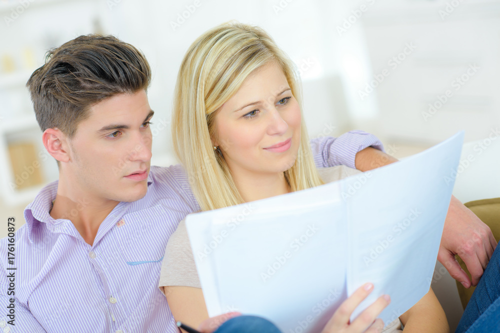 Couple reading through an important document Couple reading through an important document