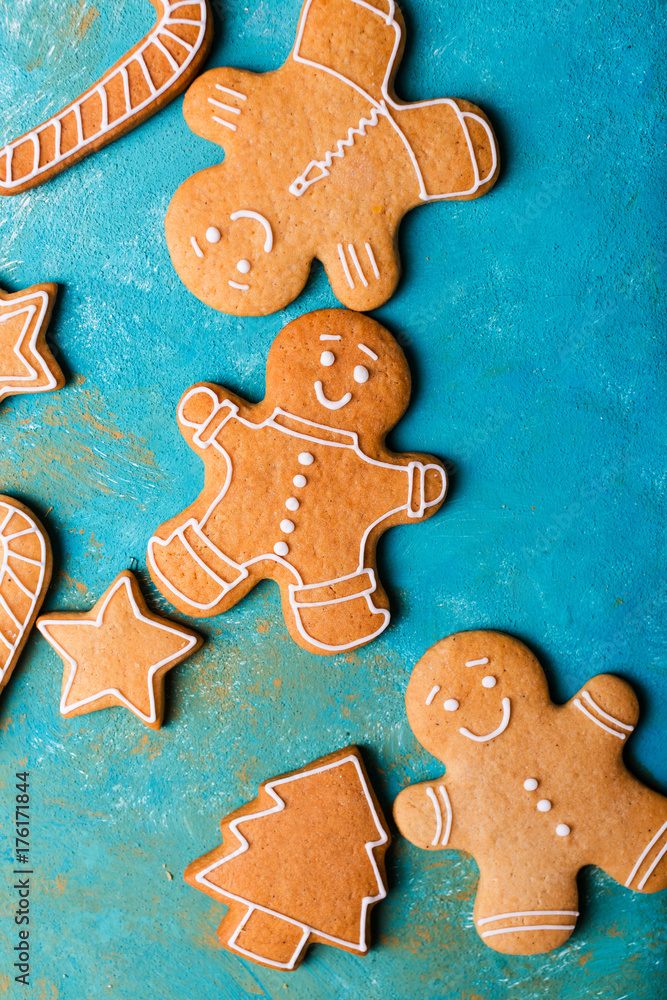 Ginger men with colored glaze on a turquoise background .. Gingerbread. Christmas cookies. Ginger man in a colored sweater. Ginger men with colored glaze on a turquoise background .. Gingerbread. Christmas cookies. Ginger man in a colored sweater.