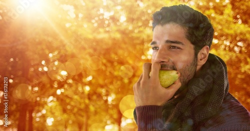 Man in Autumn eating pear in forest