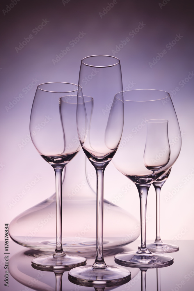 Glassware selection with wine, champagne, liquour glasses and decanter on creative background Glassware selection with wine, champagne, liquour glasses and decanter on creative background
