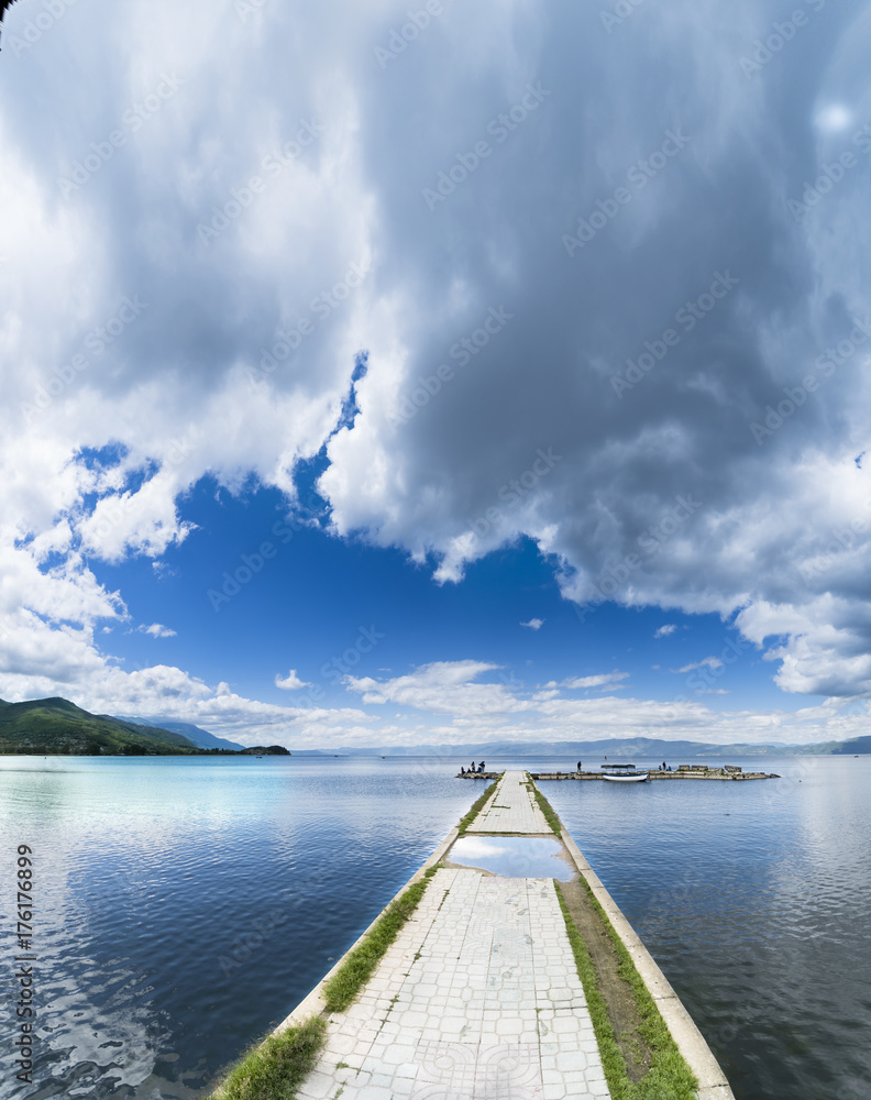Empty boat port on calm water surface lake in Ohrid, Macedonia, sky copyspace, vertical