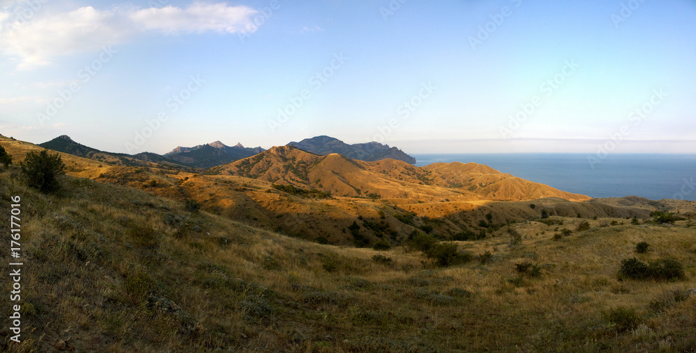 Colorful highland landscape of a deep blue sea, rocky mountains under blue clear sky.Crimean mountains landscape in the summer season/Beautiful view of mountains, ocean,sky, ships on clear summer day