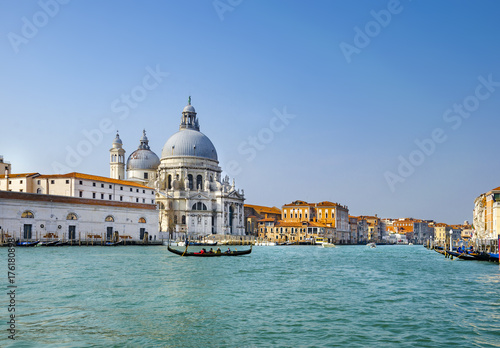Beautiful view of traditional Gondolas on Canal Grande with historic Basilica di Santa Maria della Salute in the background on a sunny day in Venice, Italy © zefart