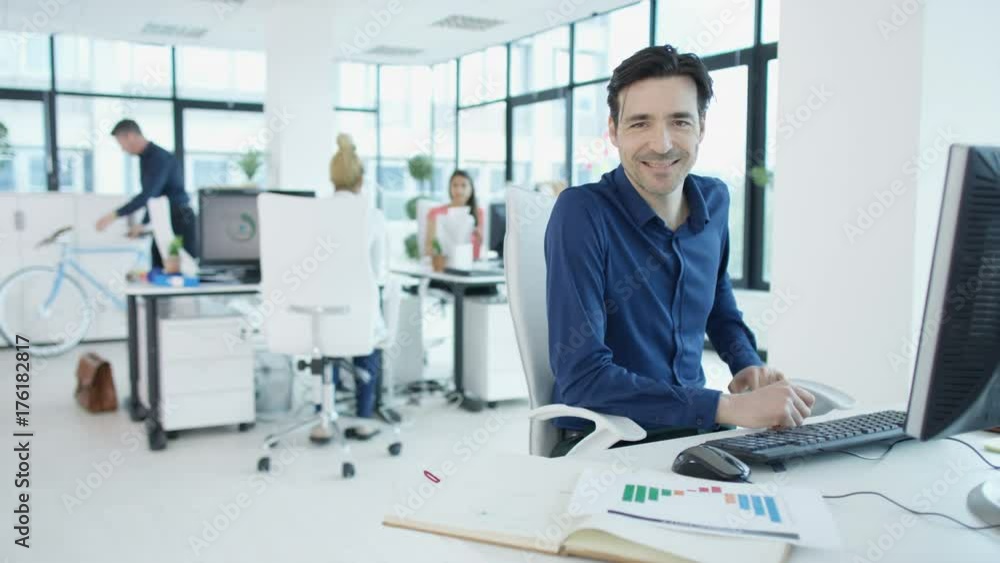 Portrait smiling businessman working at his desk in modern office Portrait smiling businessman working at his desk in modern office