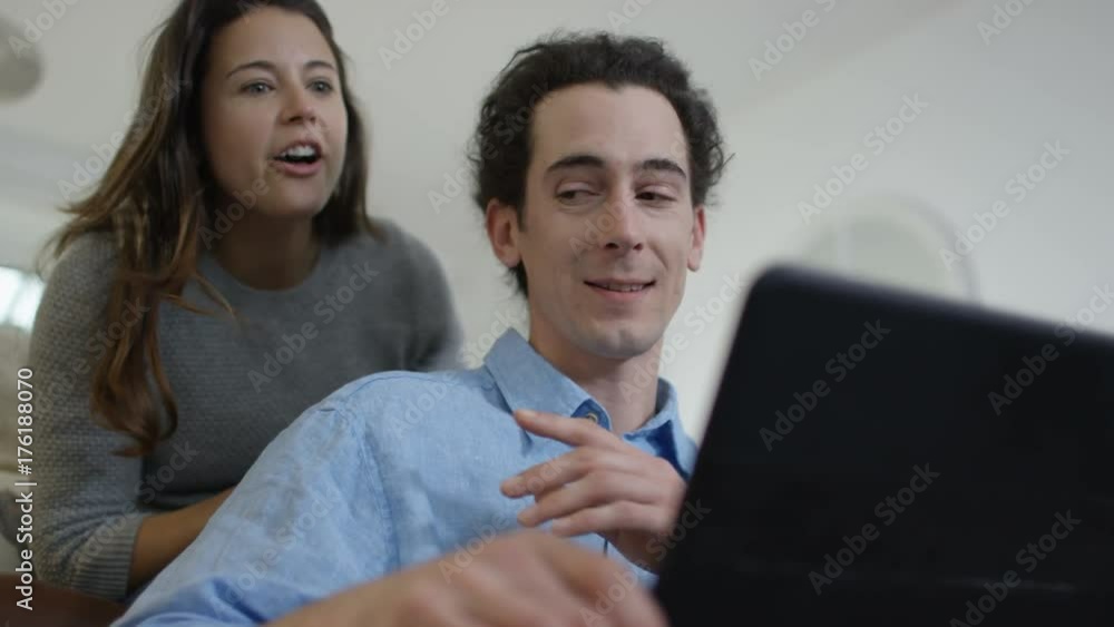 Cheerful couple relaxing at home & making video call on laptop Cheerful couple relaxing at home & making video call on laptop