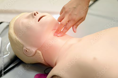 check pulse - CPR First Aid Training with CPR dummy in the class