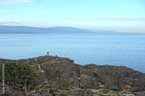  Einzelne Frau im Hintergrund betrachtet szenische Aussicht auf Meer und Inseln.