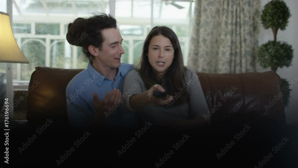 Couple fighting over the remote control in front of TV Couple fighting over the remote control in front of TV