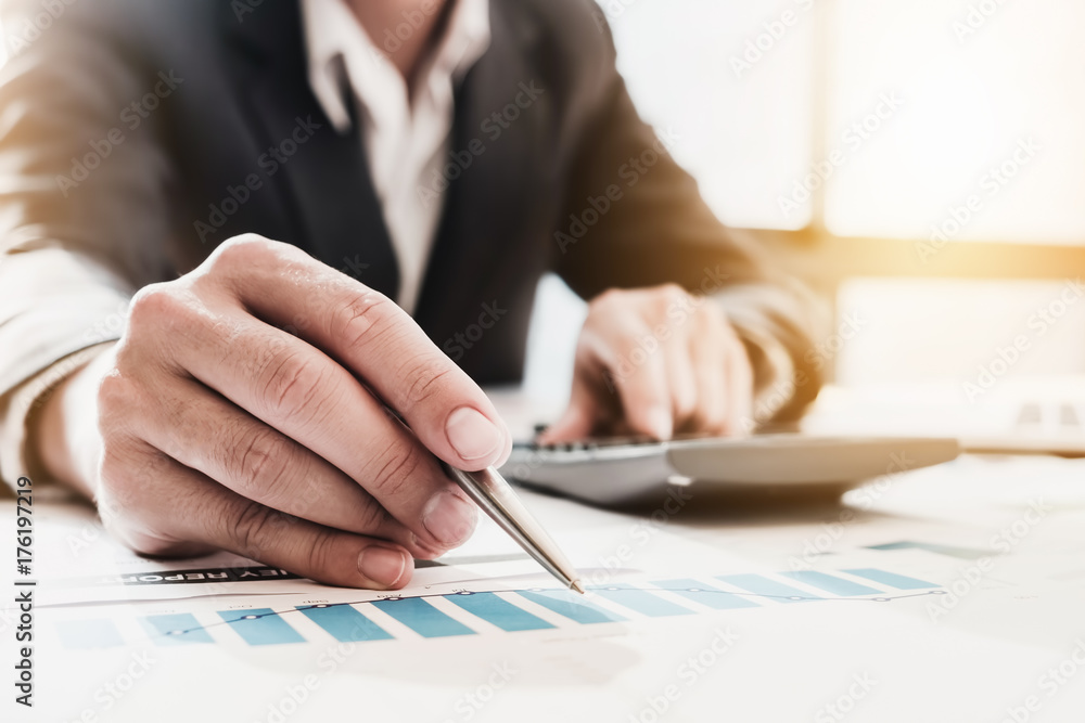 Businessman pen pointing graph chart in this mounth and use calculator for Plans to improve quality next month. Businessman pen pointing graph chart in this mounth and use calculator for Plans to improve quality next month.