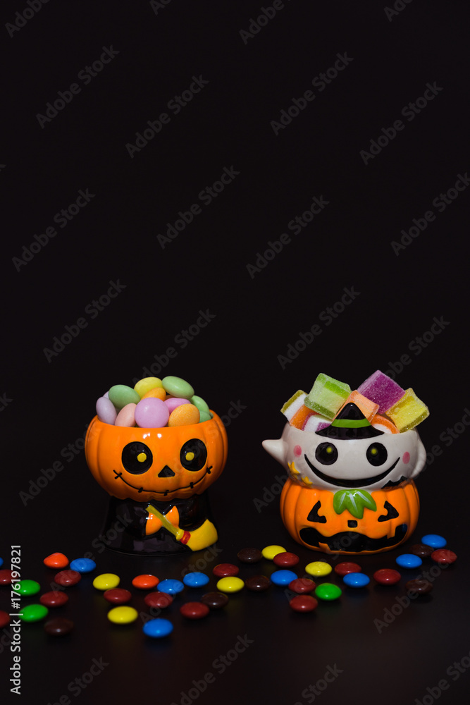 Halloween pumpkin doll head Jack lantern with candy on black background ,trick or treat Halloween pumpkin doll head Jack lantern with candy on black background ,trick or treat
