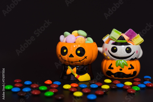 Halloween pumpkin doll head Jack lantern with candy on black background  trick or treat