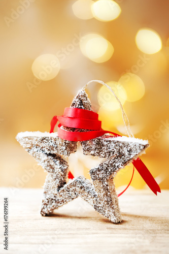Christmas Card with wooden toy in a shape form and red ribbon on abstract defocused bokeh background. Xmas concept, poster, banner.